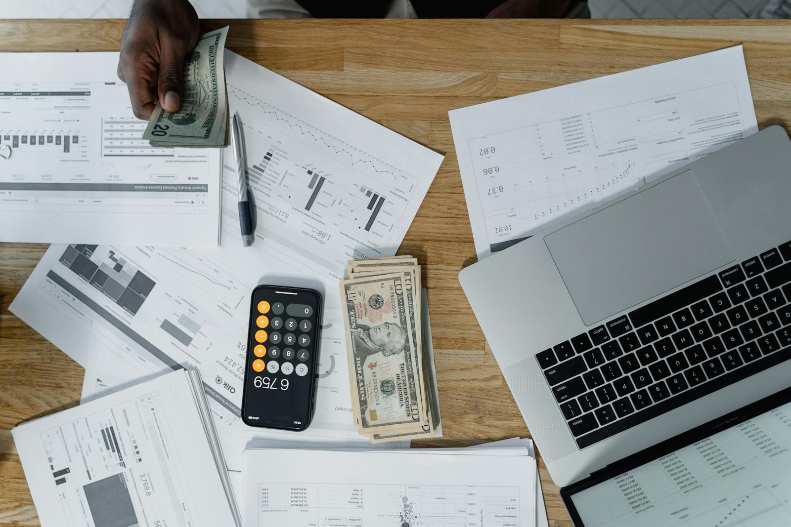 Mortgage paperwork, cash, and planning documents on a desk